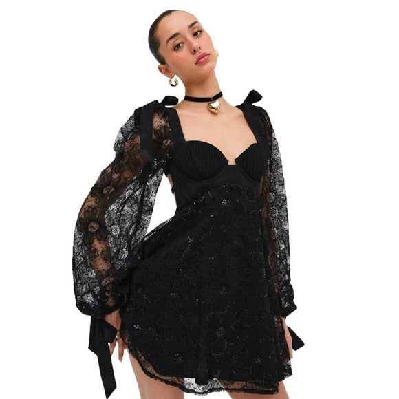 Kiersten Mini van For Love & Lemons - zwarte kanten mini-jurk met transparante mouwen te huur bij POOMBIES, jurk huren voor gala of feest