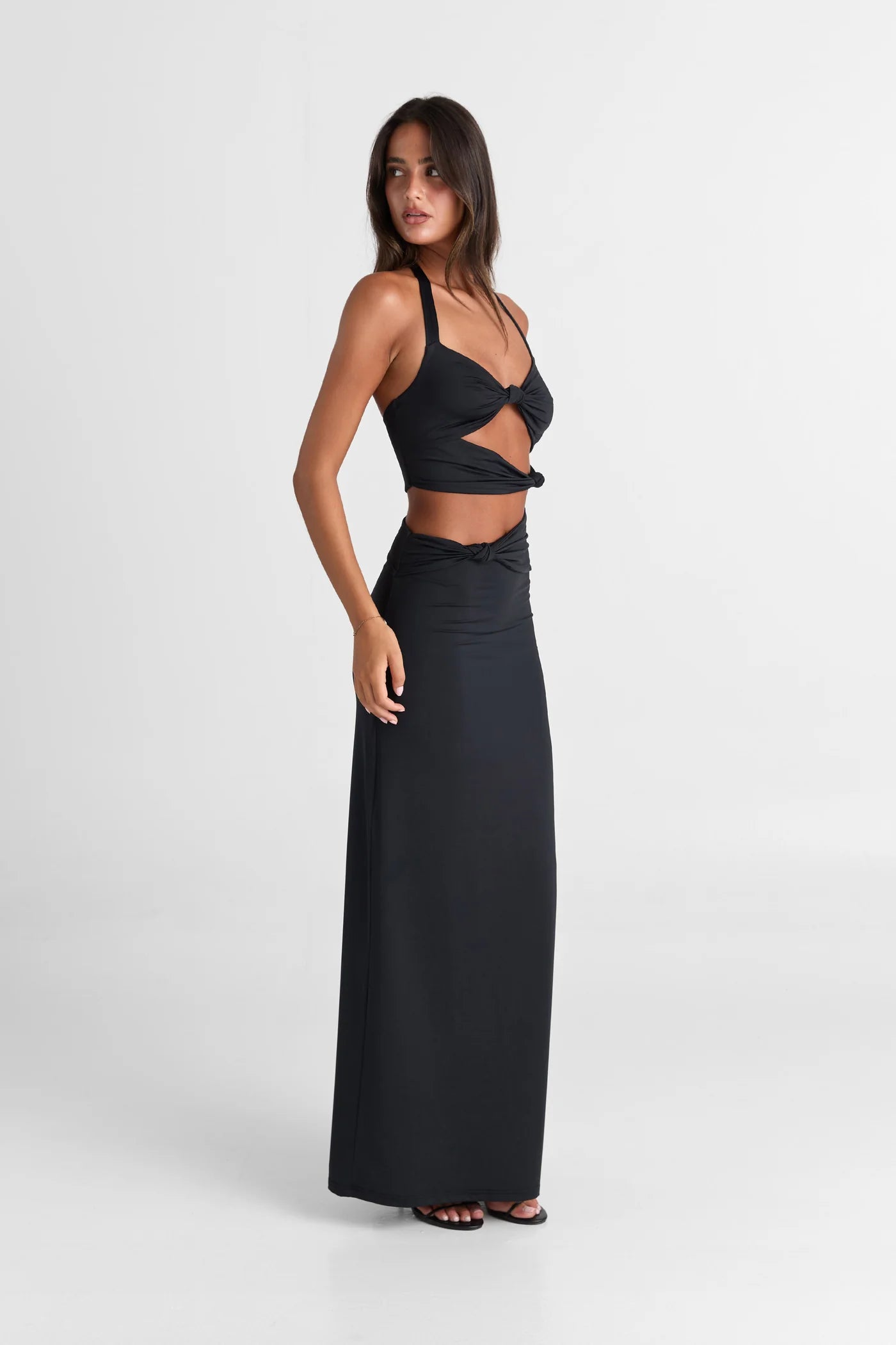 Oralia Zwart van Sasha Therese - zwarte maxi-jurk met halternek en cut-outs te huur bij POOMBIES, jurk huren voor gala of feest