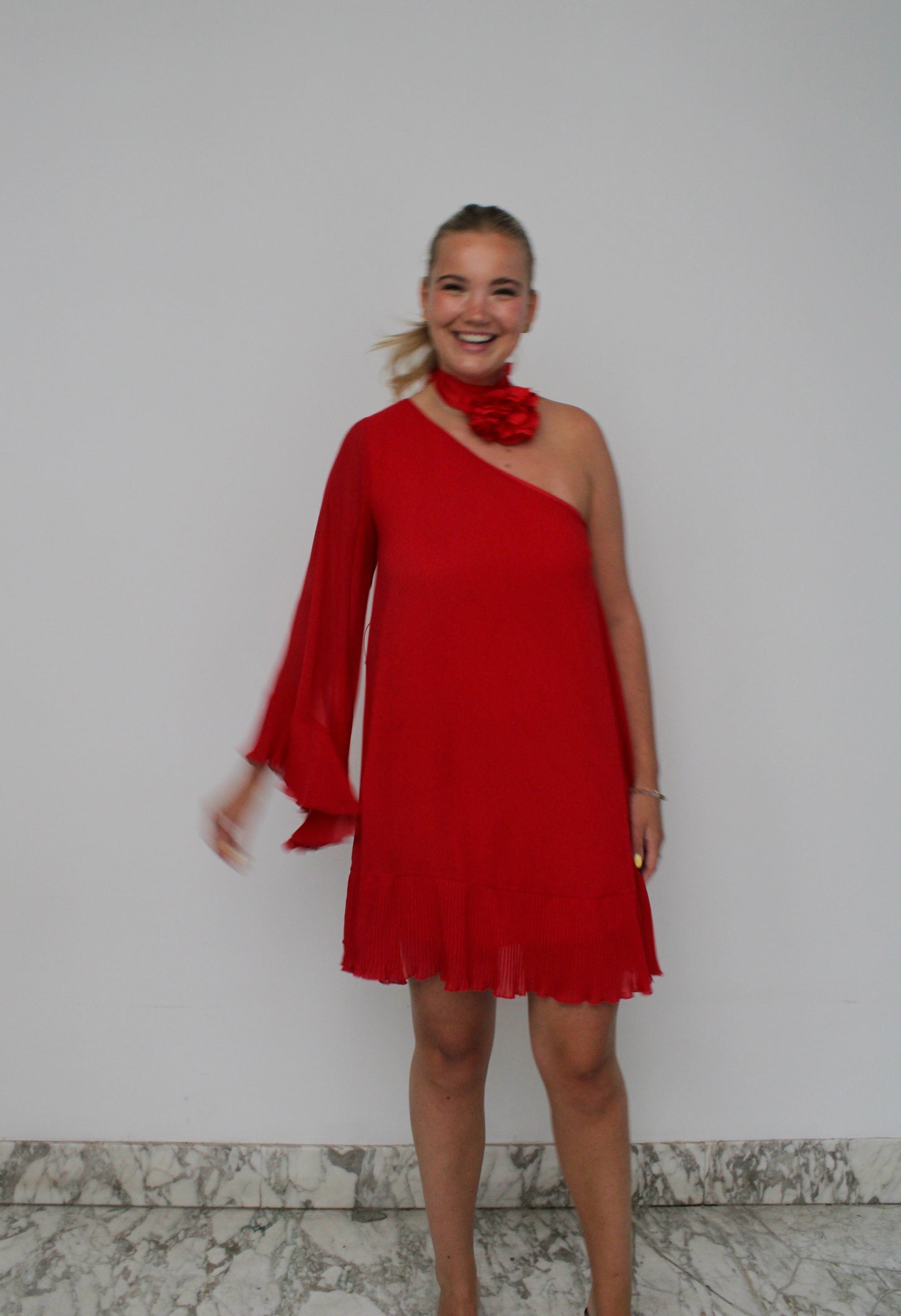 One Shoulder van Aniye By - rode one-shoulder jurk met bloem sjaaltje te huur bij POOMBIES, jurk huren voor gala of feest