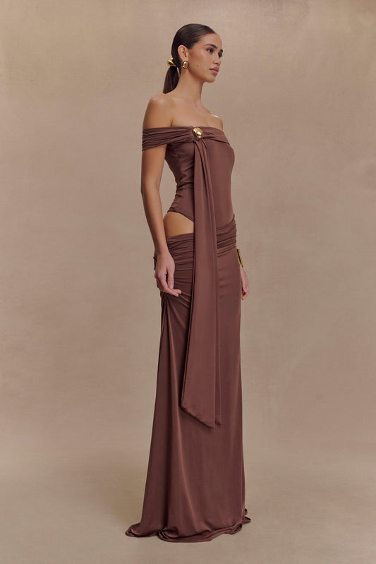 Oliver van Meshki - mochabruine off-shoulder maxi-jurk met cut-out en gouden detail te huur bij POOMBIES, jurk huren voor gala of feest
