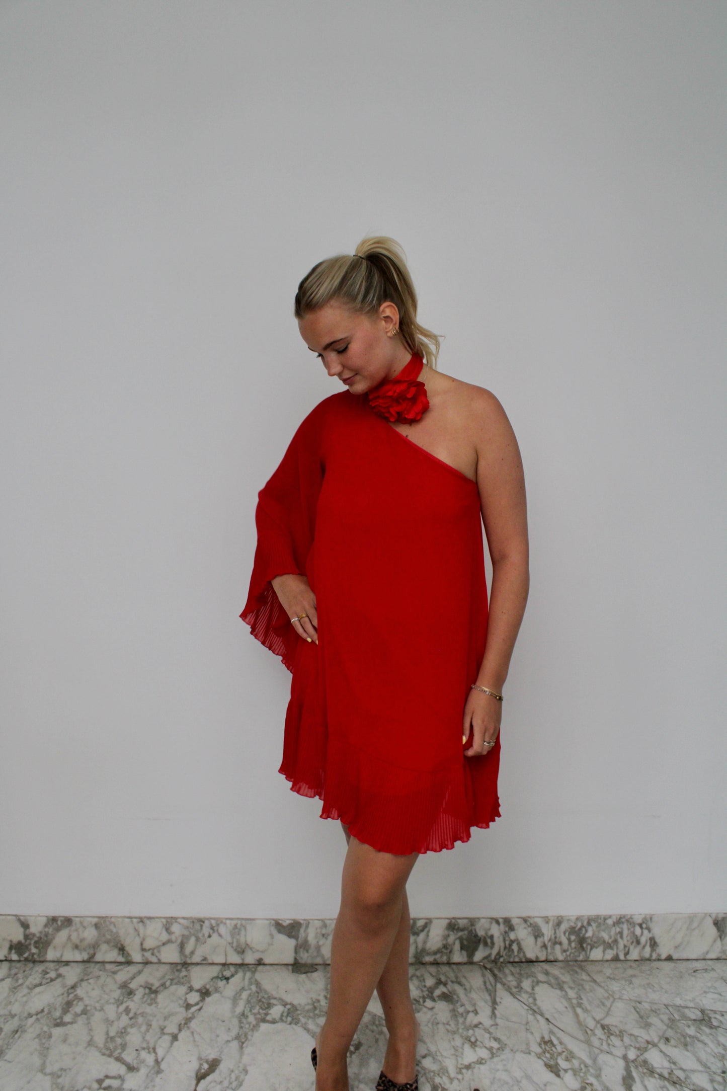One Shoulder van Aniye By - rode one-shoulder jurk met bloem sjaaltje te huur bij POOMBIES, jurk huren voor gala of feest