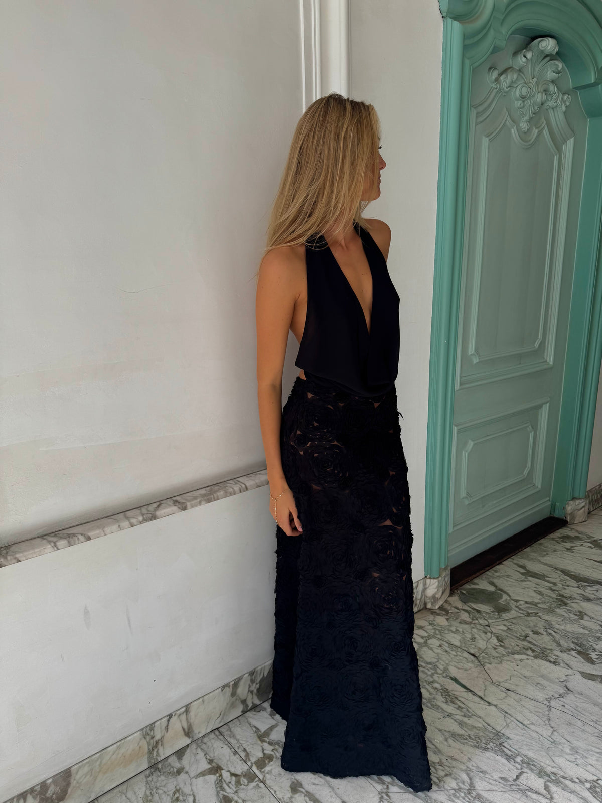 Adriana jurk van Arcina Ori in zwart - lange georgette maxi jurk met rose appliqué en cowl hals te huur bij Poombies, jurk huren voor bruiloft, gala of chiquedag